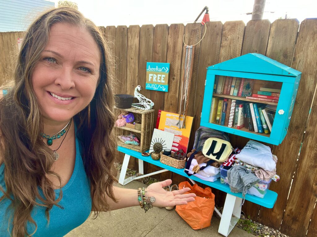 Holly Reville in front of her Community Giving Bench and Free Book Library.
